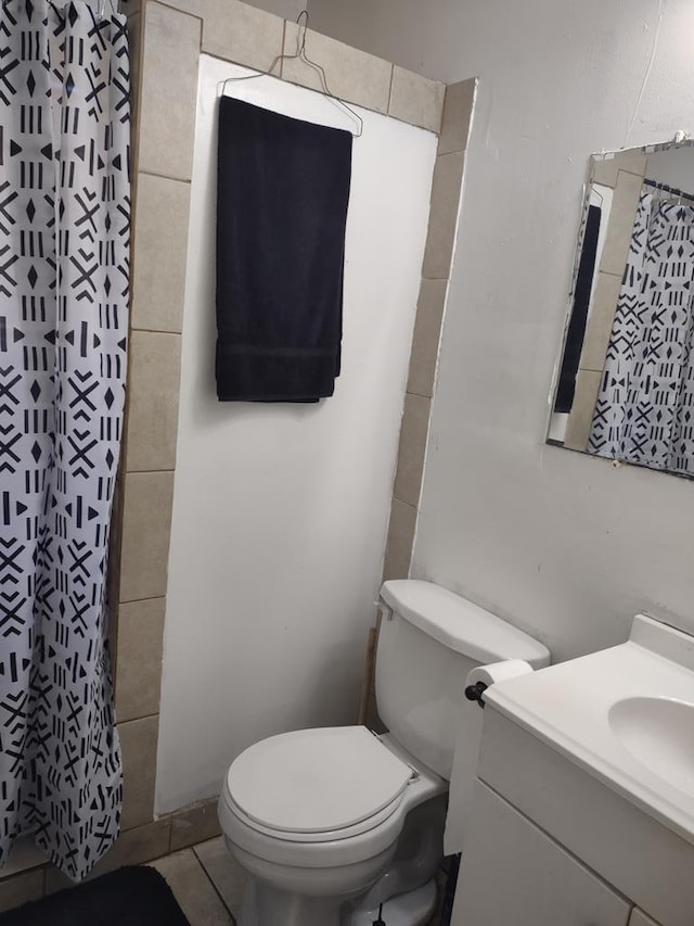 bathroom featuring curtained shower, vanity, and toilet