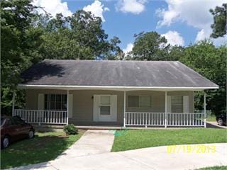 ranch-style home featuring a front yard and covered porch