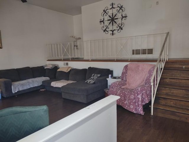 living area featuring visible vents, stairway, and wood finished floors