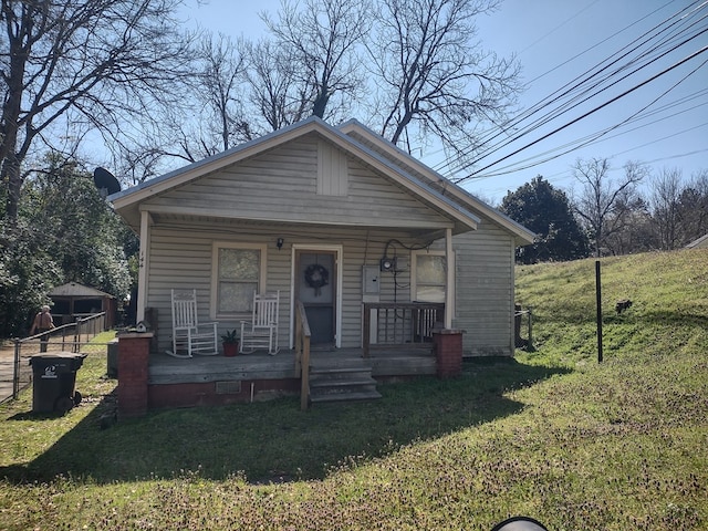 bungalow-style home with a front lawn and covered porch