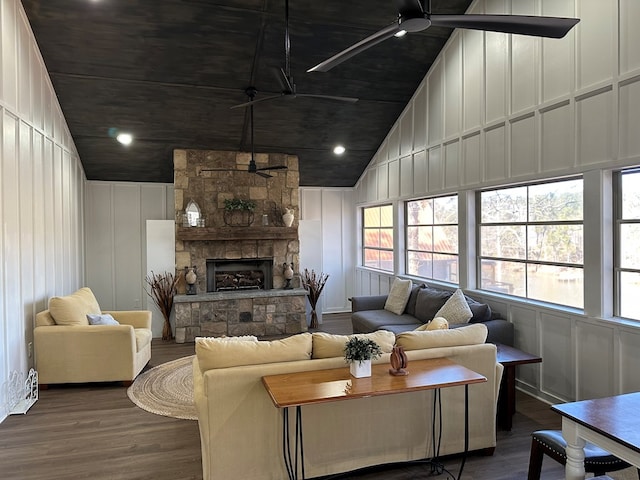 living room featuring dark wood-type flooring, a fireplace, high vaulted ceiling, and ceiling fan