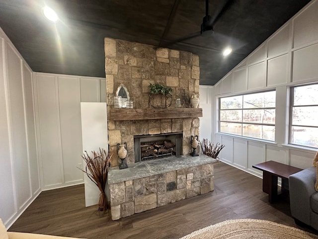 living room with a fireplace, vaulted ceiling, and dark hardwood / wood-style floors