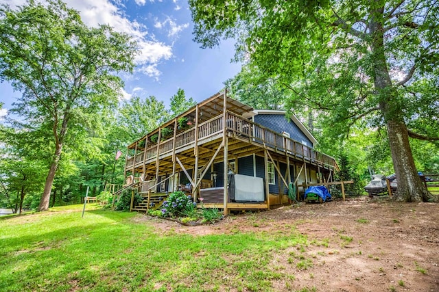 rear view of property featuring a lawn and a wooden deck