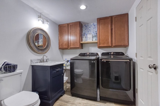 clothes washing area featuring washer and dryer, recessed lighting, a sink, light wood-type flooring, and laundry area