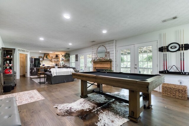 recreation room featuring a textured ceiling, pool table, wood finished floors, visible vents, and french doors