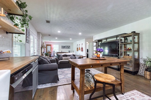 living area with dark wood-style floors, recessed lighting, visible vents, and a textured ceiling