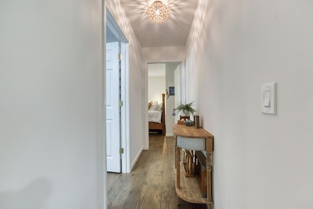 corridor featuring wood finished floors and baseboards