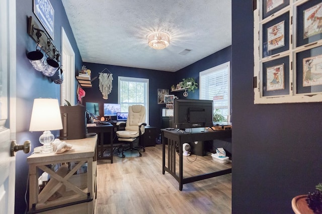 home office featuring a textured ceiling, wood finished floors, and visible vents