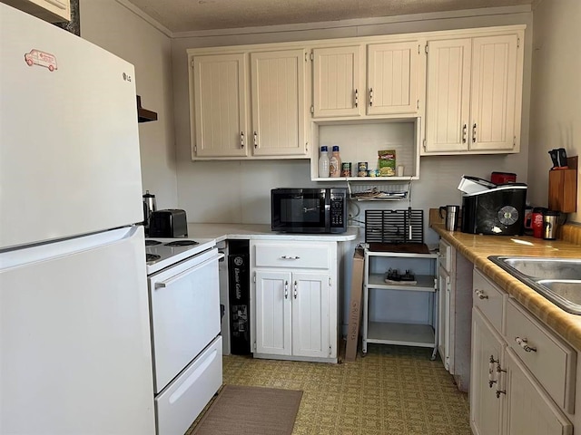 kitchen featuring sink, white cabinets, and white appliances