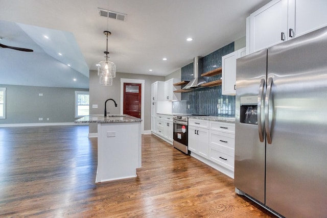 kitchen featuring decorative light fixtures, stainless steel appliances, white cabinetry, and a kitchen island with sink