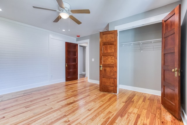 unfurnished bedroom featuring ceiling fan, light hardwood / wood-style floors, and a closet