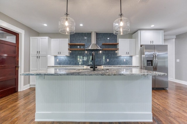 kitchen featuring stainless steel refrigerator with ice dispenser, white cabinetry, and a kitchen island with sink