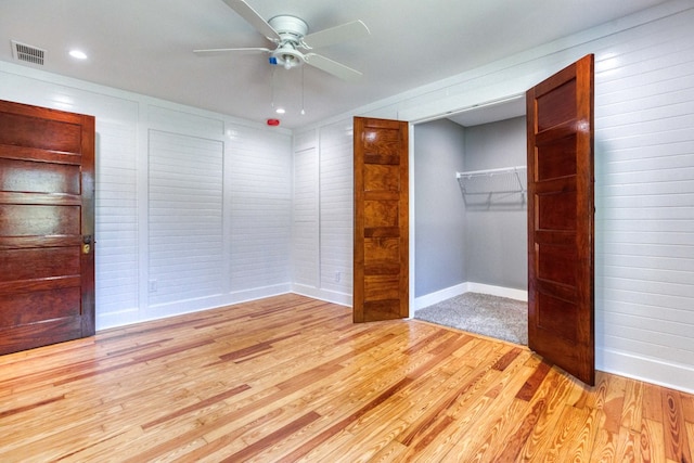 unfurnished bedroom with ceiling fan, a closet, and light wood-type flooring