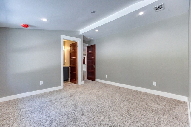 carpeted spare room with lofted ceiling