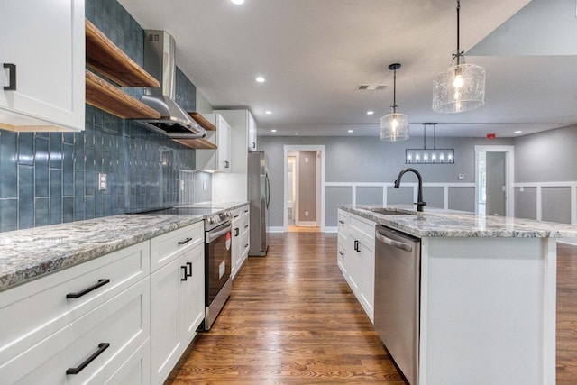 kitchen featuring white cabinetry, sink, decorative light fixtures, a kitchen island with sink, and appliances with stainless steel finishes