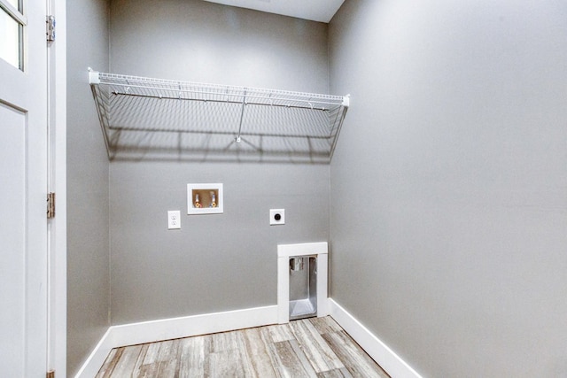 clothes washing area featuring hookup for an electric dryer, light hardwood / wood-style floors, and washer hookup