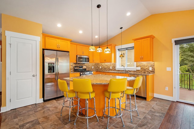 kitchen with pendant lighting, a kitchen island, stainless steel appliances, and wood-type flooring