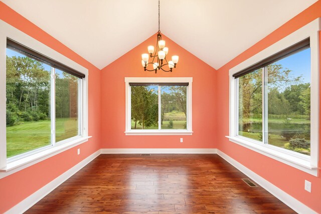 interior space with dark hardwood / wood-style flooring, plenty of natural light, a notable chandelier, and lofted ceiling