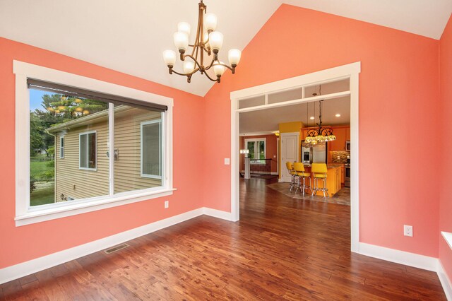 unfurnished room featuring vaulted ceiling, a notable chandelier, and dark hardwood / wood-style flooring