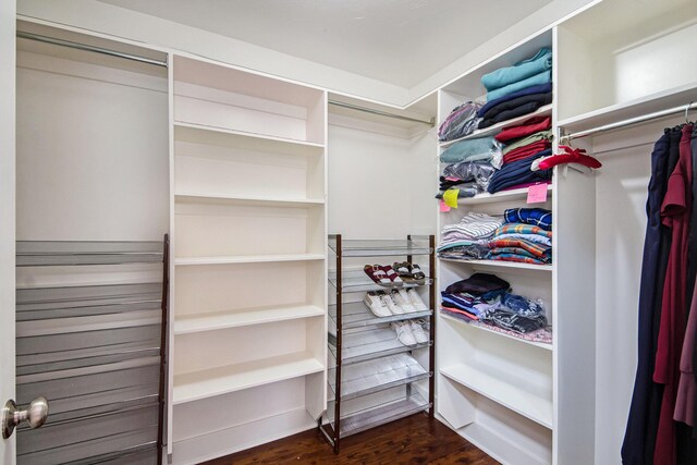 walk in closet with dark wood-type flooring