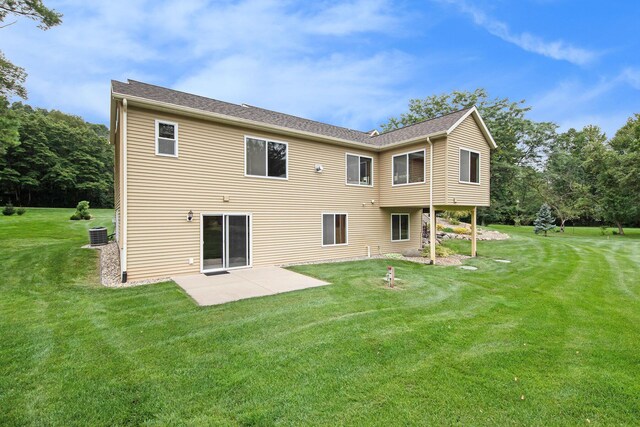 rear view of property featuring central AC, a lawn, and a patio