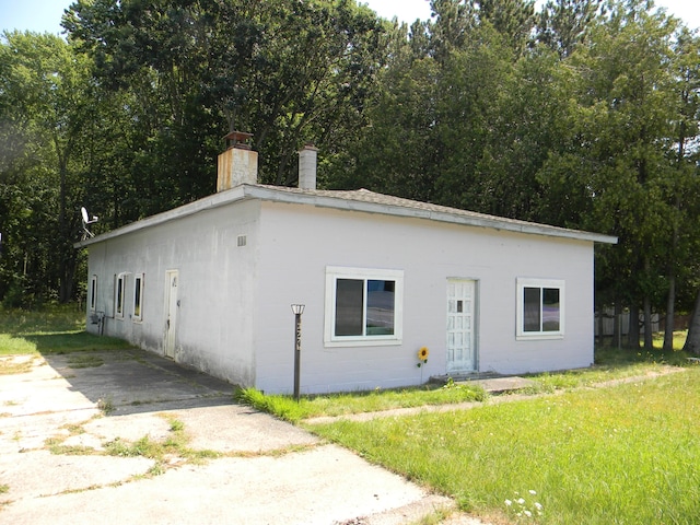 view of front facade with a chimney and a front yard