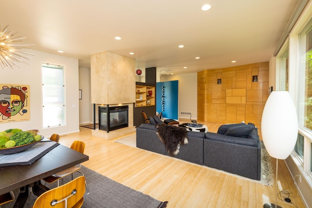 12737 Sanctuary Pl, Grand Haven, MI 49417 - living area featuring plenty of natural light, a multi sided fireplace, wood finished floors, and recessed lighting