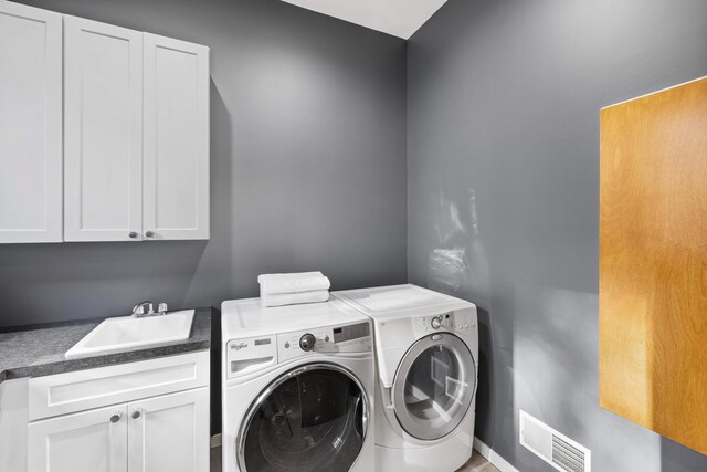 12737 Sanctuary Pl, Grand Haven, MI 49417 - laundry room featuring cabinet space and washing machine and clothes dryer