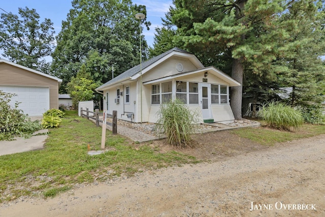 view of front of property featuring a garage and a sunroom