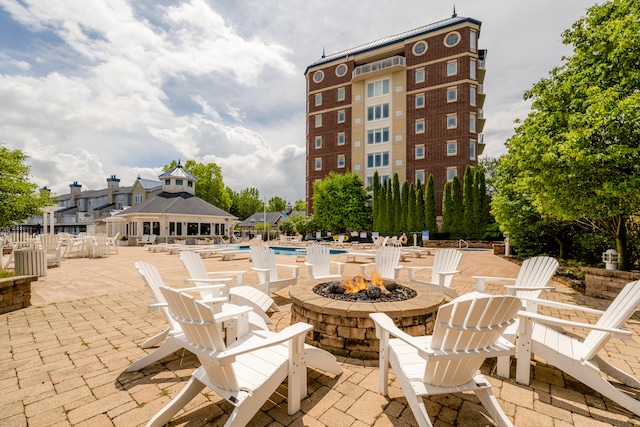 view of patio featuring a fire pit, a community pool, and a gazebo