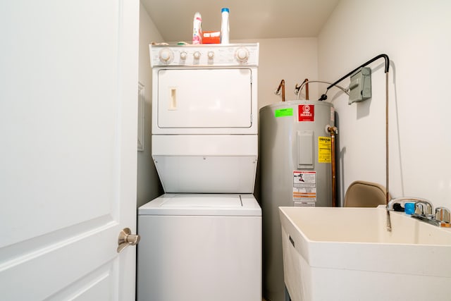 laundry area with sink, electric water heater, and stacked washer / drying machine