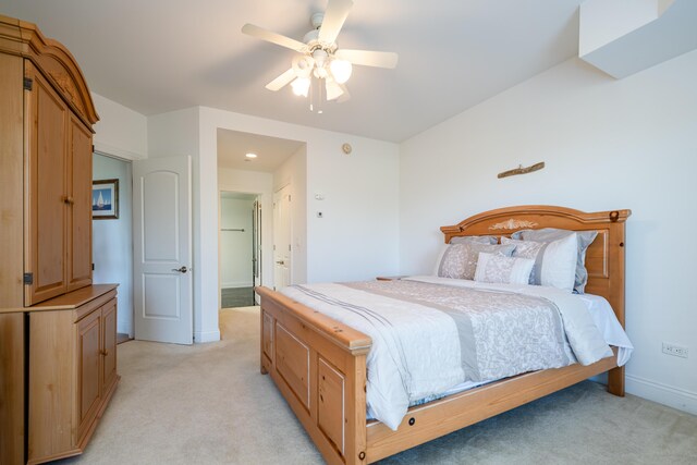 bedroom featuring light colored carpet, baseboards, and ceiling fan