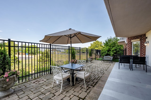 view of patio featuring outdoor dining space and fence