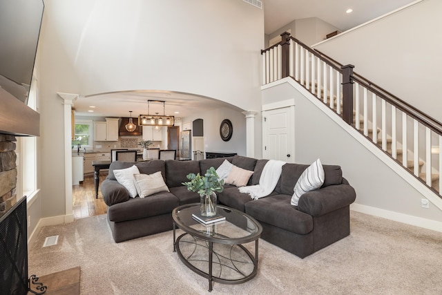 carpeted living room featuring ornate columns