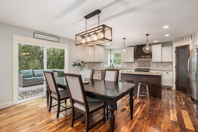 dining space with sink and wood-type flooring