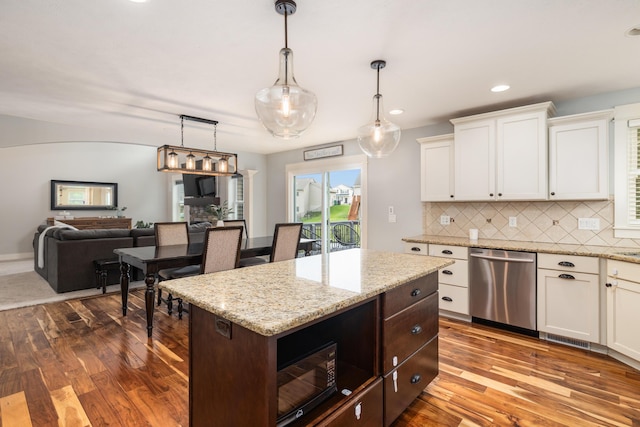 kitchen featuring white cabinetry, stainless steel dishwasher, decorative light fixtures, and backsplash