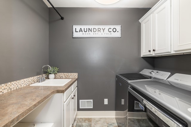 laundry room with cabinets, sink, and washer and clothes dryer