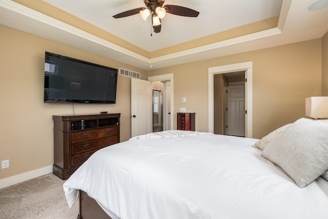 bedroom with a raised ceiling, carpet, and ceiling fan