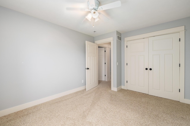 unfurnished bedroom with ceiling fan, a closet, and light carpet