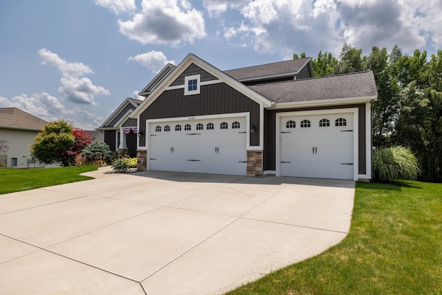 craftsman inspired home with a garage and a front lawn