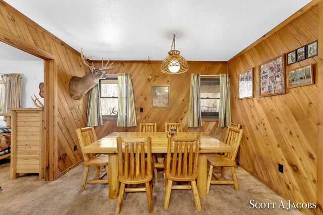 dining room with wooden walls and light colored carpet