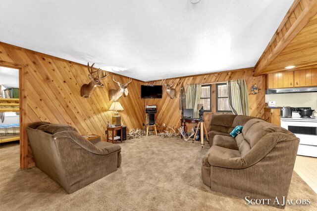 carpeted living room with beam ceiling and wooden walls