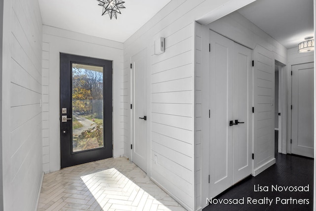 foyer entrance featuring wood walls