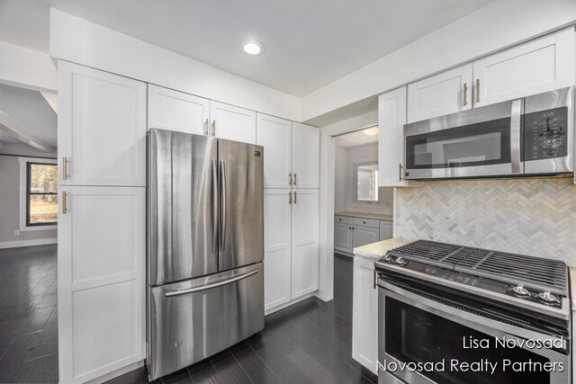 kitchen with tasteful backsplash, stainless steel appliances, and white cabinets