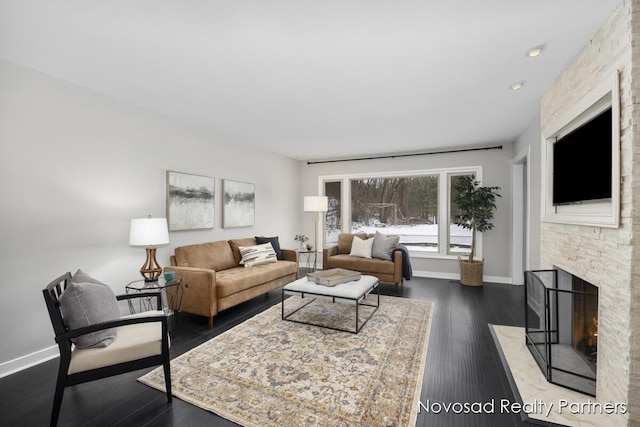 living room with dark wood-type flooring and a fireplace