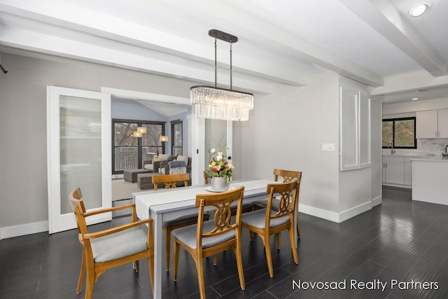 dining space featuring an inviting chandelier, sink, beam ceiling, and dark hardwood / wood-style flooring