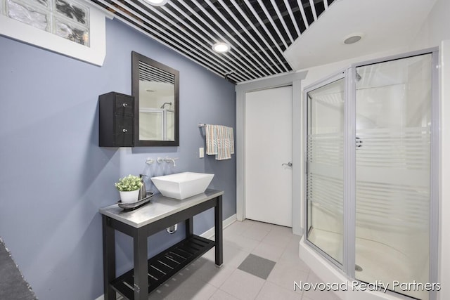 bathroom featuring sink, tile patterned floors, and a shower with door