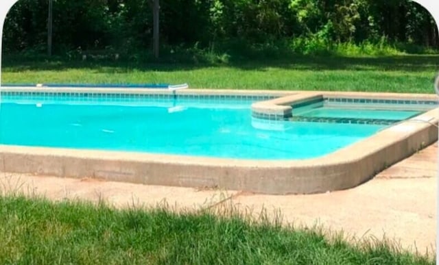 view of pool with a lawn