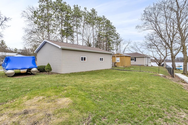 exterior space with fence, an outdoor structure, and a lawn
