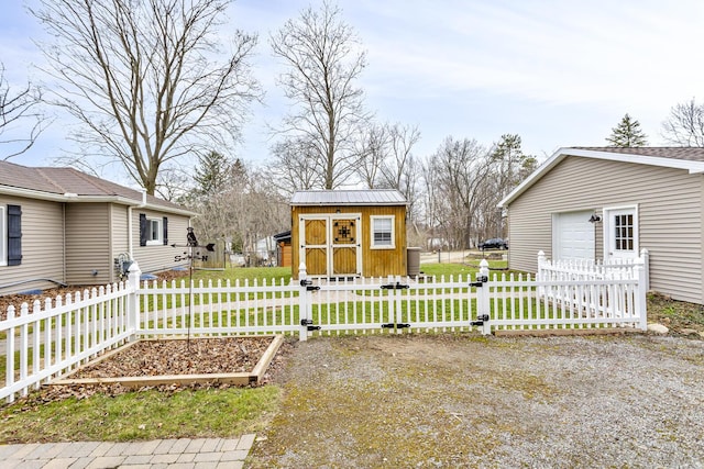 view of yard with a garden, a garage, fence private yard, and an outdoor structure